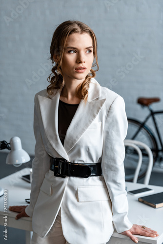 beautiful stylish woman in white formal wear looking away