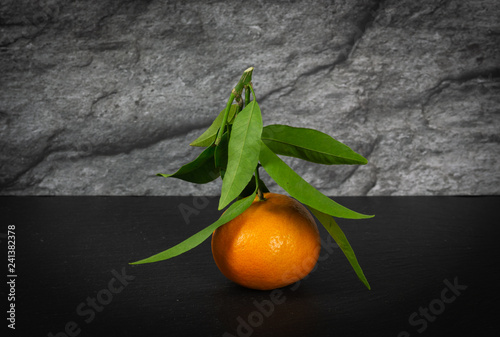 Mandarins with green leaves on black background