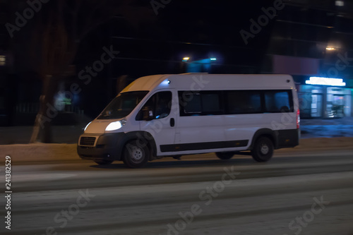 minibus moves along the night street