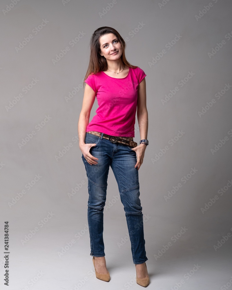 girl model in pink shirt and blue jeans in Studio on light background Stock  Photo | Adobe Stock