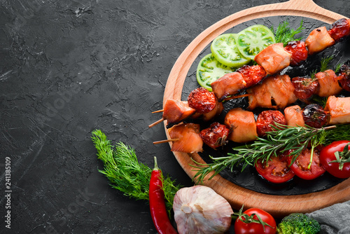 Chicken shish kebab with cherry tomatoes on a black background. Meat. Top view. Free copy space.