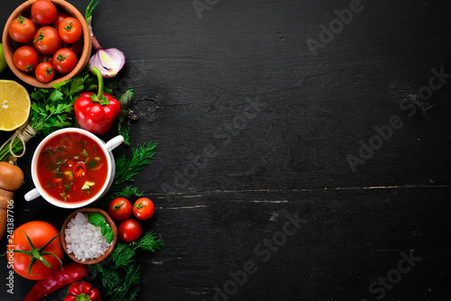 Vegetable background. Fresh tomatoes, paprika, onions and parsley on the table. Top view. On a black background. Free space for text.