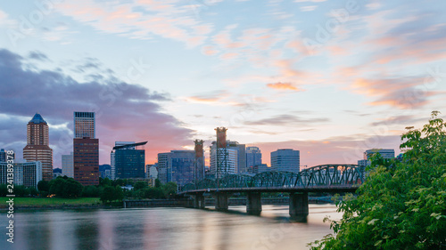 Hawthorne Bridge over Willamette River at sunset with skyline of downtown Portland, USA