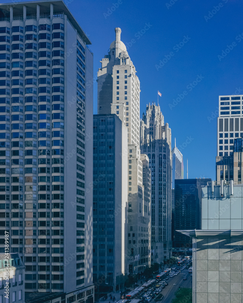 Buildings and skyscrapers over street with buses and cars, in downtown Chicago, USA