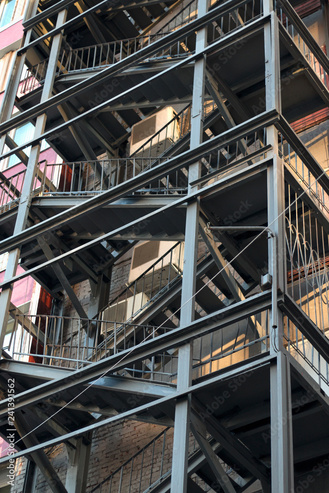 Metal fire escape of high building. Close-up view. Vertical image