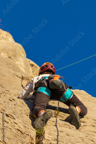 boy climbing mountain with rope