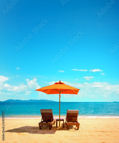 Fototapeta Naklejka Na Ścianę i Meble -  Two lounge chairs with sun umbrella on a beach