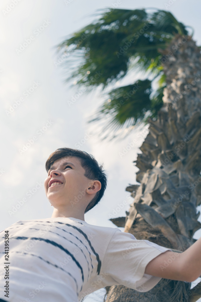 Boy under coconut palm tree and sky Boy under coconut palm tree and sky
