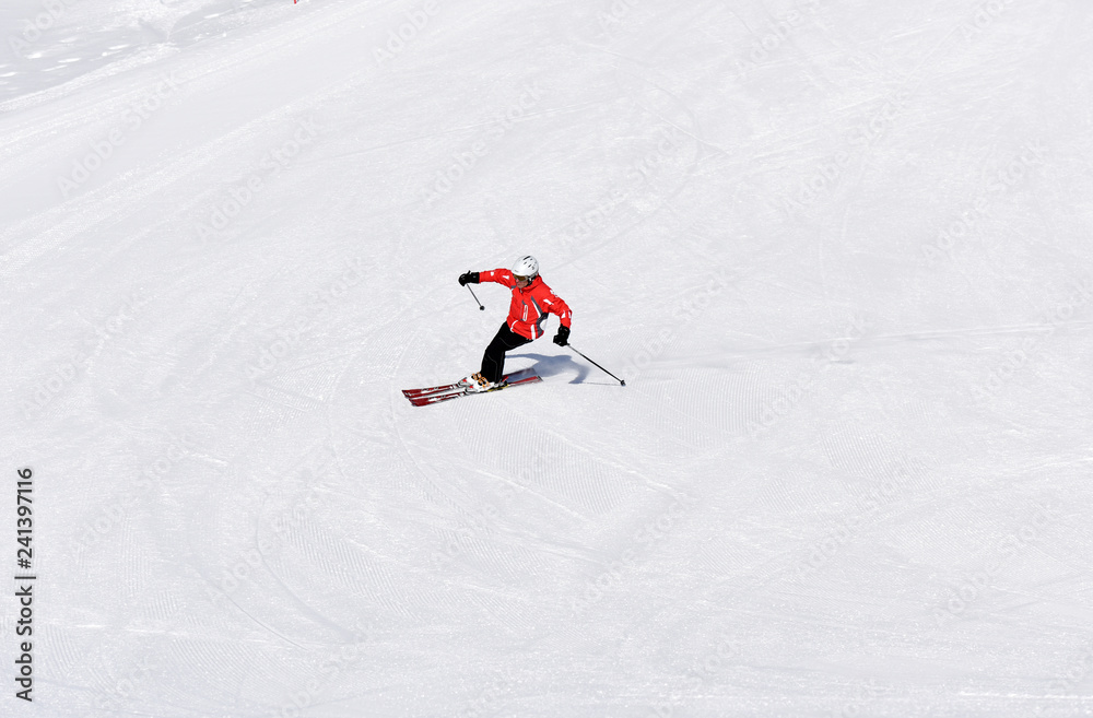 Skier skiing downhill during sunny day in high mountains. Italy, Europe. Skier skiing downhill during sunny day in high mountains. Italy, Europe.