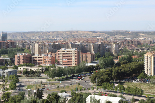 A landscape of the Actur district in Zaragoza, with some apartment blocks, boulevards, streets and dry hills on the background, in Aragon, Spain