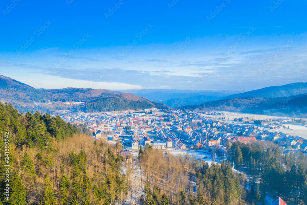 Croatia, Delnice, Gorski kotar, panoramic view of town center from drone in winter, mountain landscape in background, houses covered with snow 