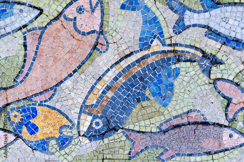 Fish mosaic decoration made of tale. Old, vintage abstract colorful background from small ceramic tiles square lead. Venetian mosaic as decorative backdrop.