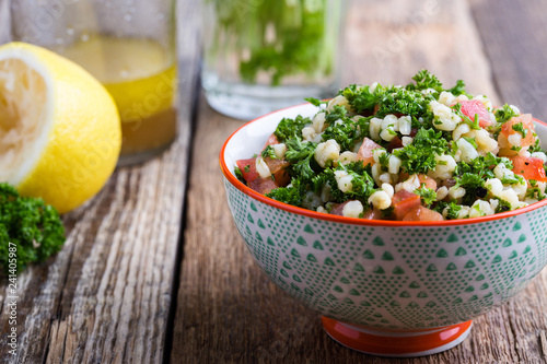 Tabbouleh salad with bulgur, fresh parsley, tomatoes and salad dressing