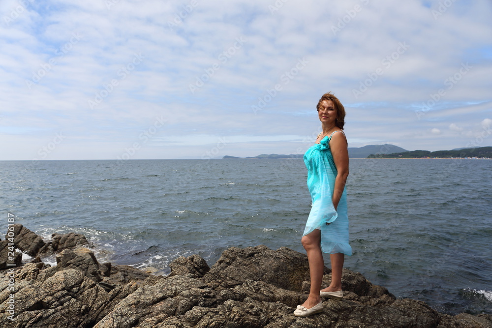 happy young woman standing on the rocks