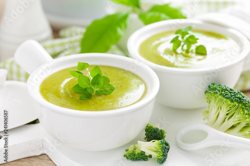 Broccoli soup in bowls on wooden kitchen table closeup. Healthy vegetarian dish. Diet food