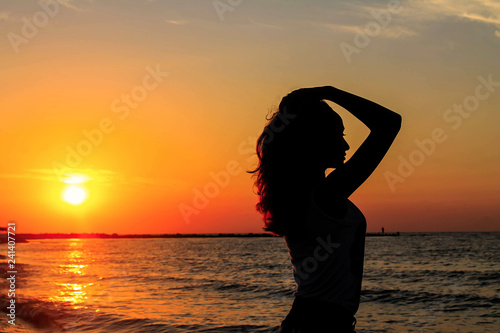 Nice girl profile silhouette on the sea sunrise. Beautiful woman in sea during sunset. Girl in sea.