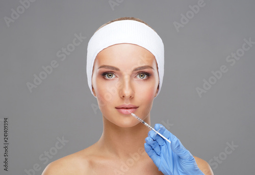 Doctor injecting in a beautiful face of a young woman. Plastic surgery concept.