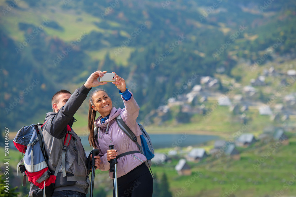 Two hikers taking selfie on top of the mountain