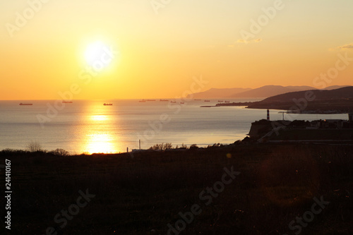 sunset in the Black sea. In the foreground is the Gelendzhik lighthouse and the entrance to Gelendzhik Bay. Then you can see the coast to Novorossiysk.