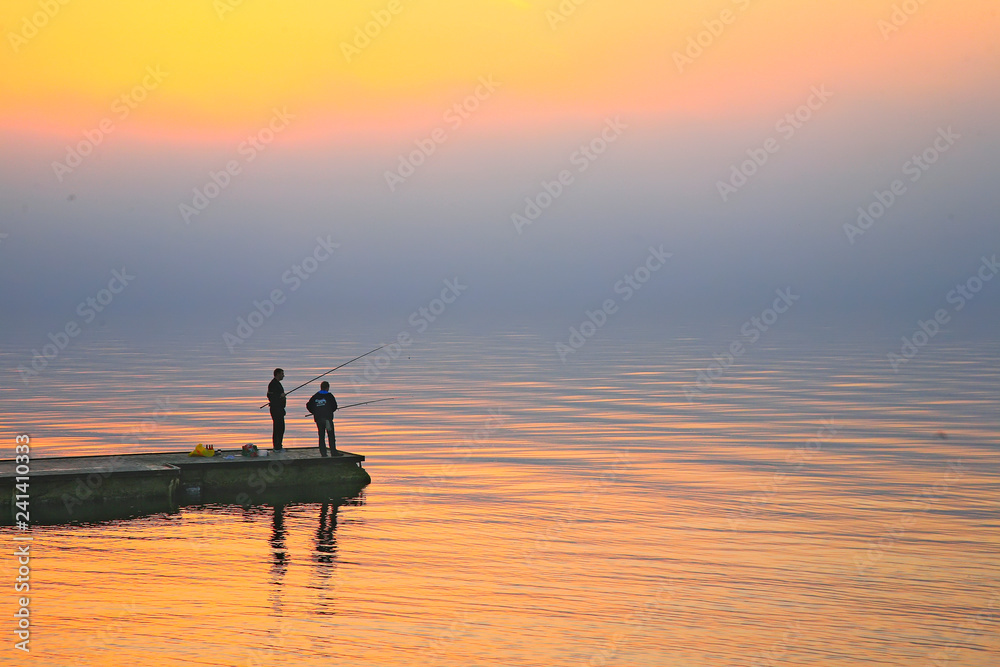 Panorama of fishermen at sunset in Gelendzhik Bay. Fishermen stand on the pier at sunset. Silhouettes
