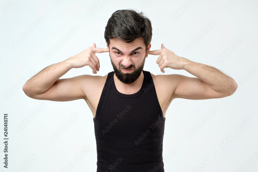Young hispanic man closing ears with fingers. Young hispanic man closing ears with fingers.