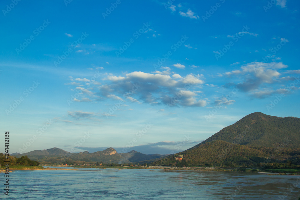 Mountains and River with a white cloud and blue sky background.