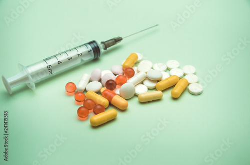 syringe and pills are on the table, medical supplies are on the table
