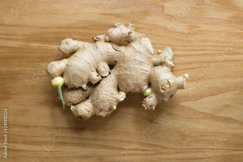 Ginger root sliced on wooden background 