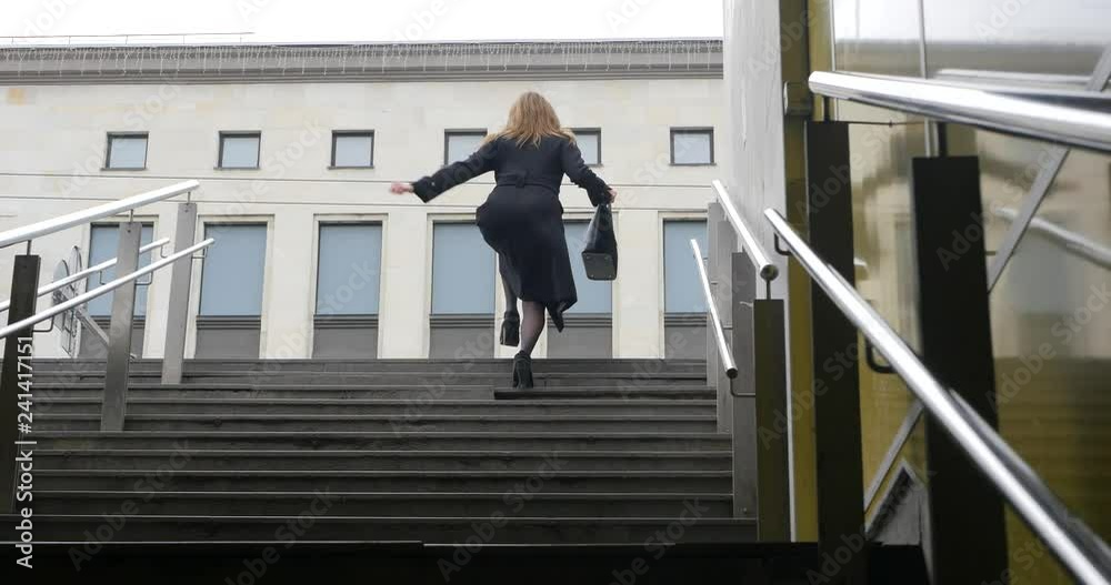 Young woman running up the stairs