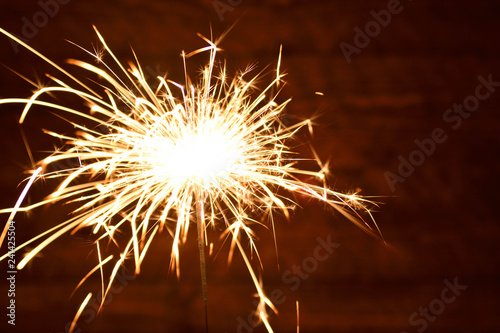 Holiday Bengal lights on the dark background. Burning sparkler  Happy New Year.