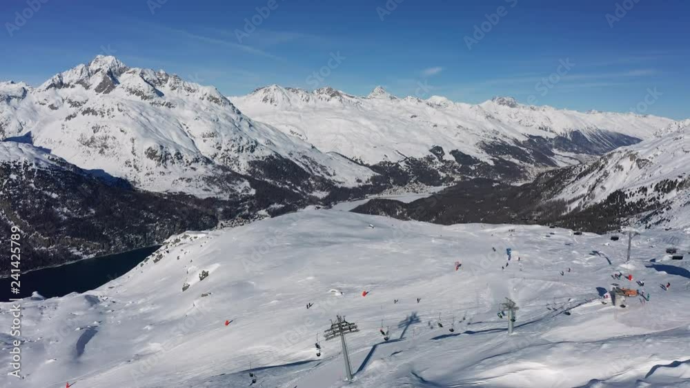 Aerial view of Swiss Alps mountains in winter, snow on slopes, sunny day with blue sky - ski resort St. Moritz, landscape panorama of Switzerland, Europe
