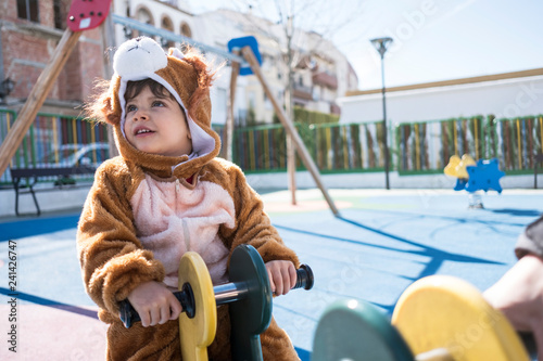 Little kid with bear or lion costume playing in playground park