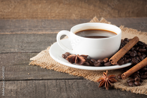 Coffee cup and beans on a rustic background. Coffee Espresso and a piece of cake with a curl. Cup of Coffee and coffee beans on table.