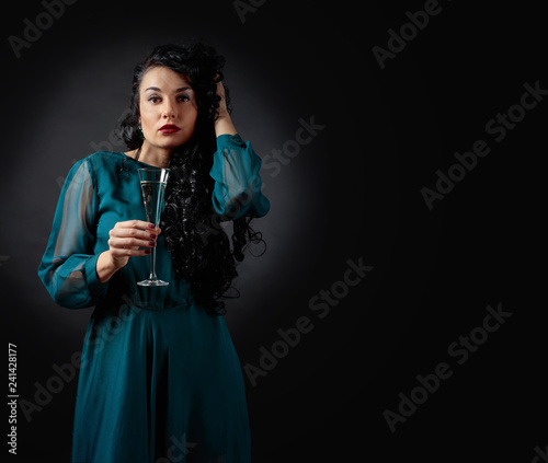 Young beautiful woman with long curly hair in evening gown.