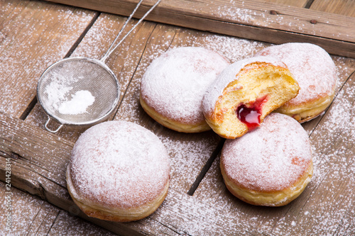 Traditional Polish donuts on wooden background.  Tasty doughnuts with jam. photo