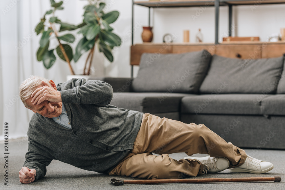© LIGHTFIELD STUDIOS - old men falled down on floor and touching forehead