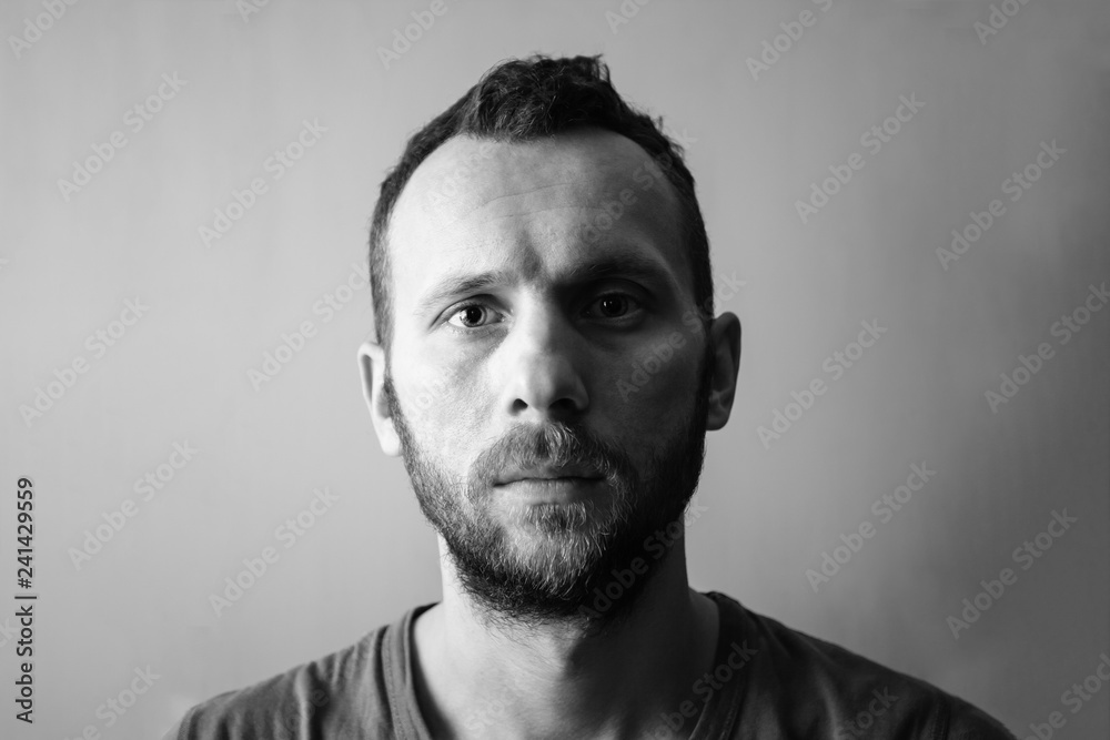 Fototapeta premium the calm face of a young man with a beard, black and white photo