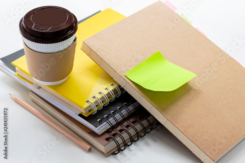 Coffee cup and double loop binding on white table.