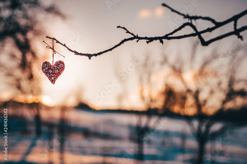 Wooden handmade heart in winter nature wit colorful pleasure colors of sunset light - valentine love wallpaper with space for your montage photo
