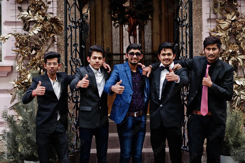 Group of 5 indian students in suits posed outdoor and show thumb up.