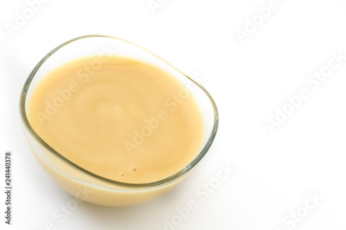 Bowl of homemade vanilla custard isolated on white background. Copyspace