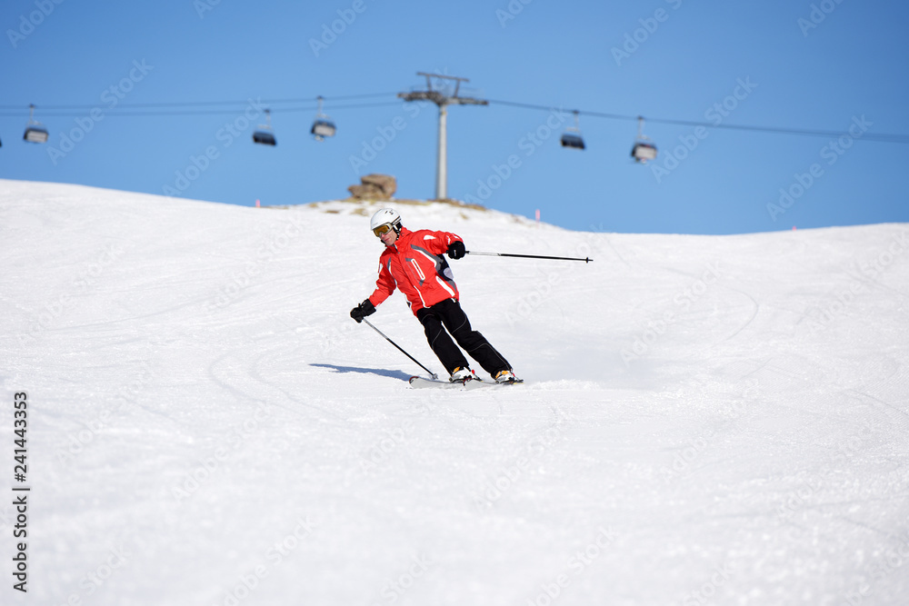 Skier skiing downhill during sunny day in high mountains. Italy, Europe. Skier skiing downhill during sunny day in high mountains. Italy, Europe.