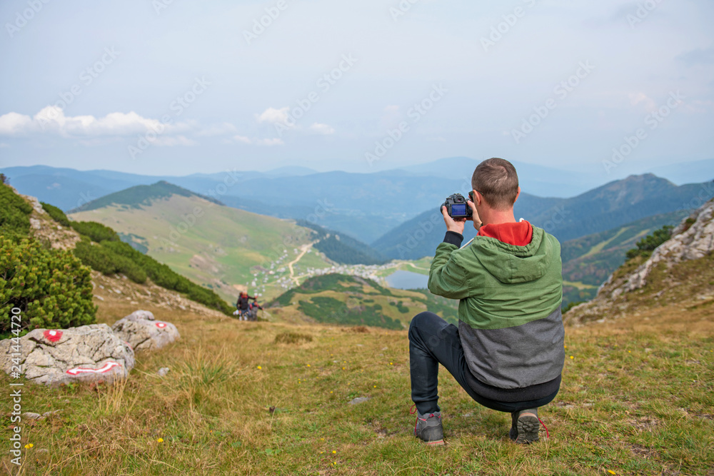 Male tourists are photographing a lake that is a natural attraction. Concept for Travel.