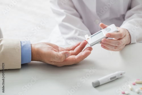 doctor measures the blood sugar level of the patient