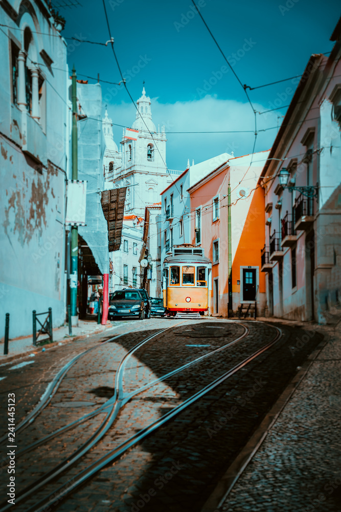 Summer cityscape of Lisboa. Red tram going down the hill along old traditional houses. sunny afternoon, narrow streets, cobblestones winding road, vacation in Lisbon