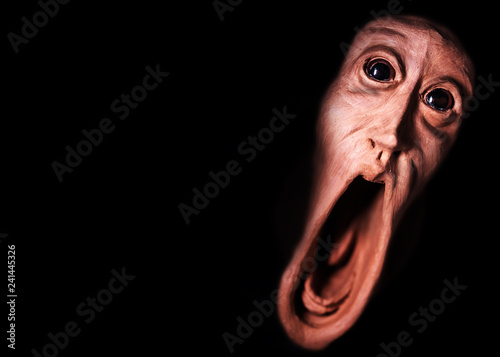 image of a panicked face screaming with bulging eyes, terrifying face. Face of fear very frightened, concept of nightmare and scare. Image for halloween or day of the dead photo