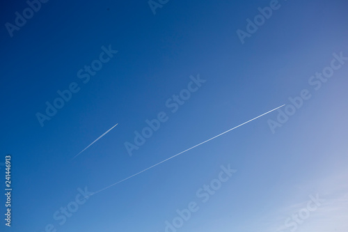 Bright blue sky with two vapour trails