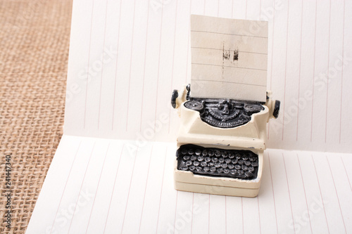 Retro syled tiny typewriter model on paper photo