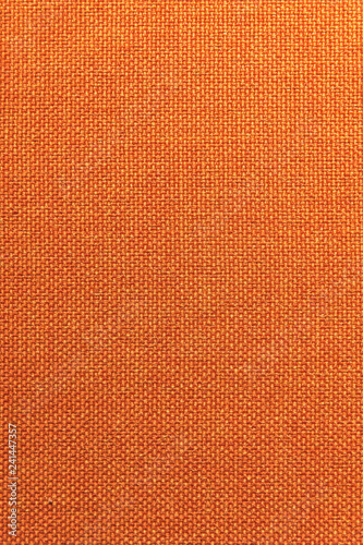 Textured background surface of textile upholstery furniture close-up. Orange color fabric structure © yanik88