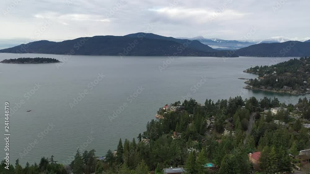 Aerial view over Burrard Inlet, ocean and island with boat and mountains in beautiful British Columbia. Canada. Aerial view over Burrard Inlet, ocean and island with boat and mountains in beautiful British Columbia. Canada.